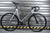 Unknown Singularity Silver fixed gear bike against garage door - full side view