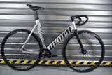 Unknown Singularity Silver fixed gear bike against garage door - full side view